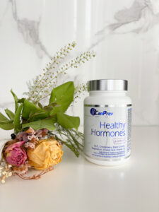 CPW Healthy Hormones on a countertop beside a small bouquet of flowers