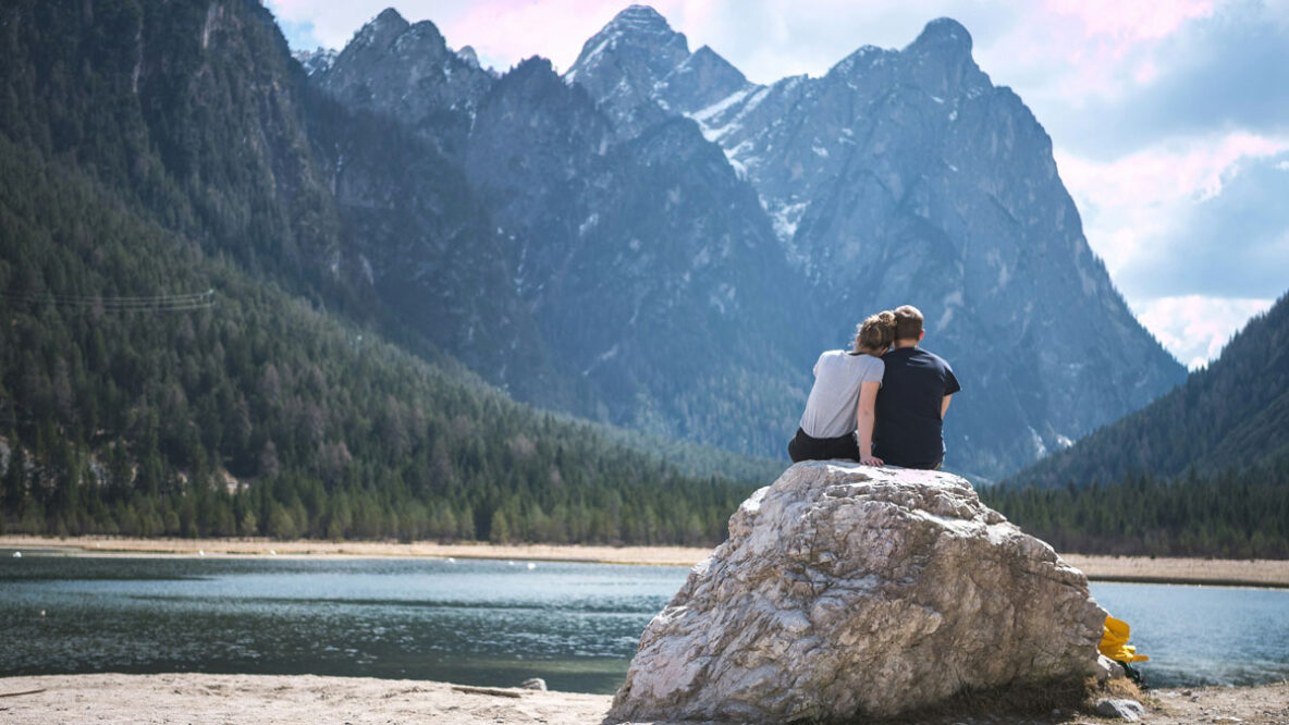 Man and woman sitting on a rock in nature